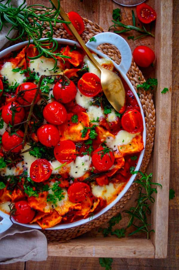 Deze ravioli ovenschotel is een echt winters comfort food gerecht dat je makkelijk op voorhand kan maken. Pasta, tomatensaus, groentjes en kaas wat heb je nu nog meer nodig. Een ideaal doordeweeks recept dat je eenvoudig vegetarisch kan maken.