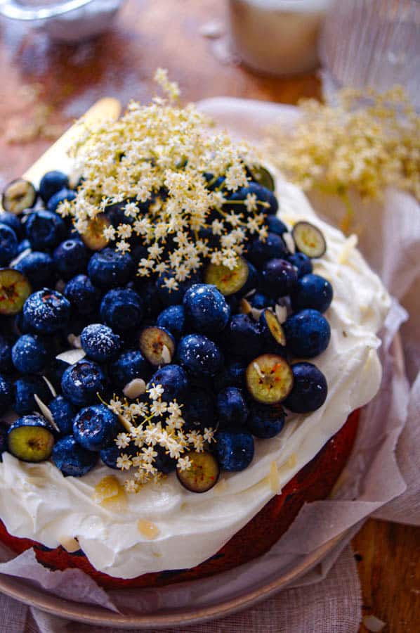 Deze blauwe bessen cake met vlierbloesem is ideaal voor bij de koffie. Een gemakkelijke cake met als geheim ingrediënt zure room en een subtiel vleugje vlierbloesem. Deze blauwe bessen cake wordt afgewerkt met een creme van mascarpone