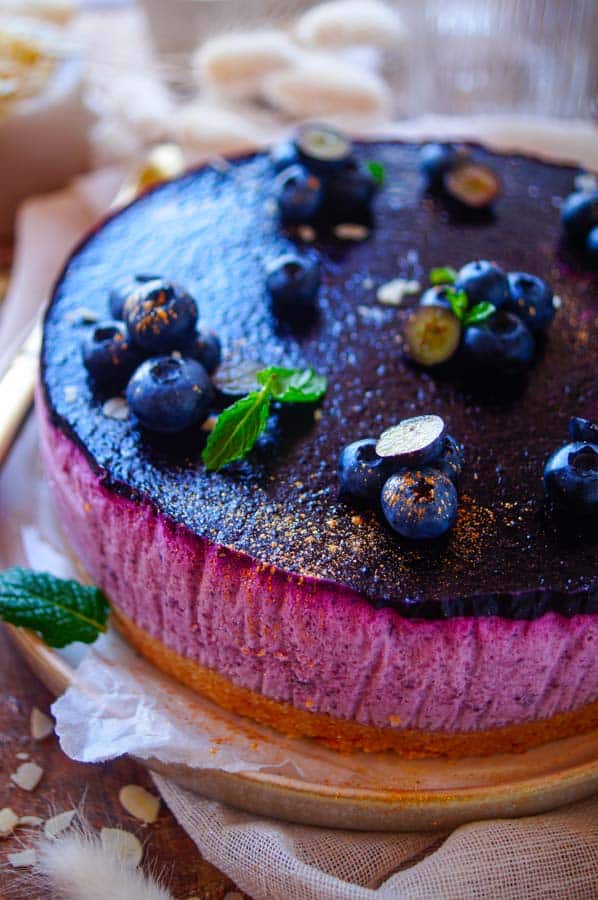 Deze Taart met blauwe bessen mousse ziet eruit als een cheesecake, dat is het dus niet. Verwacht je aan een lekkere luchtige mousse op basis van room, karnemelk en blauwe bessen. De bodem is lekker krokant met de verkruimelde koekjes.