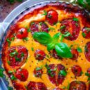 Dit recept voor de lekkerste tomaten quiche moet je gewoon op je weekmenu zetten. Makkelijk om te maken, geen hele resem aan ingrediënten en lekker luchtig. De korst is een heerlijk kruidig quichedeeg en de vulling is op basis van eieren, plattekaas of kwark en rode pesto. Als afwerking zijn er nog de verse tomaten