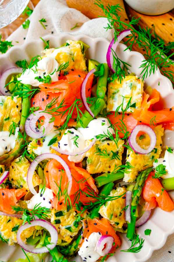 Deze makkelijke Salade met omelet en zalm is een ideaal receptje voor Pasen maar kan ook gewoon doordeweeks op je weekmenu worden gezet. De omelet maken we in de oven en bevat courgette en kaas. De salade bestaat verder uit gerookte zalm, asperges en roomkaas