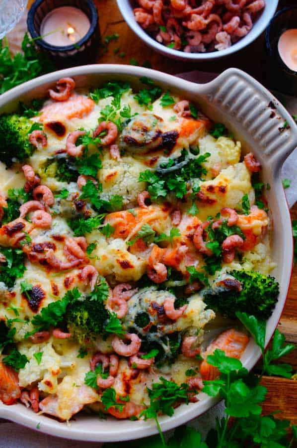 Lekker makkelijk recept voor Ovenschotel met zalm en puree, een heerlijk gerecht voor heel de familie. Je kan deze ovenschotel makkelijk op voorhand al maken. Verwacht je aan lekkere aardappelpuree, een heerlijke kaassaus, broccoli, bloemkool, zalm, kaaskorstje en garnalen.