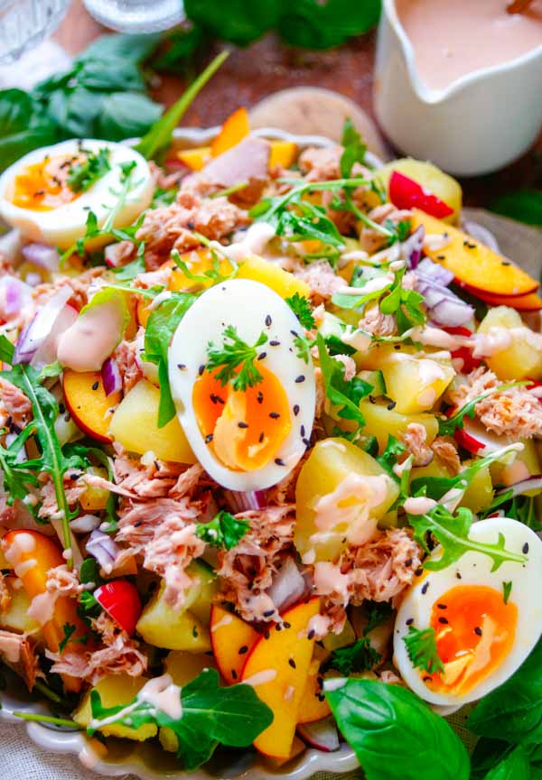 Lekker makkelijk recept voor Aardappelsalade met tonijn, een lichte zomerse avondmaaltijd voor op je weekmenu. Een gezonde salade met aardappeltjes, tonijn, groentjes, gekookt eitje, stukjes perzik en licht cocktailsausje. Snel klaar, makkelijk op voorhand te maken en ideaal om de volgende dag als lunch mee te nemen.