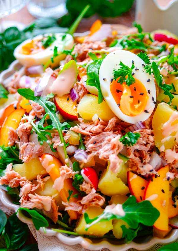 Lekker makkelijk recept voor Aardappelsalade met tonijn, een lichte zomerse avondmaaltijd voor op je weekmenu. Een gezonde salade met aardappeltjes, tonijn, groentjes, gekookt eitje, stukjes perzik en licht cocktailsausje. Snel klaar, makkelijk op voorhand te maken en ideaal om de volgende dag als lunch mee te nemen.