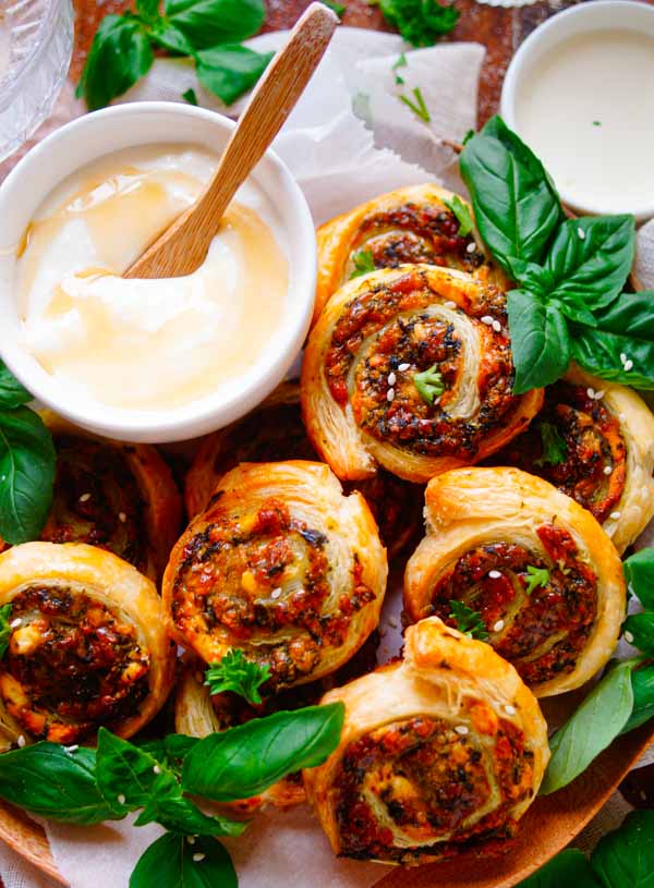 Lekker makkelijk recept voor Bladerdeeg rolletjes met feta, een snel zomers hapje voor tijdens een zomerse borrel of apéro. Deze bladerdeeg hapjes worden gevuld met een combinatie van feta, Parmezaanse kaas en spinazie. Geserveerd met een yoghurt sausje