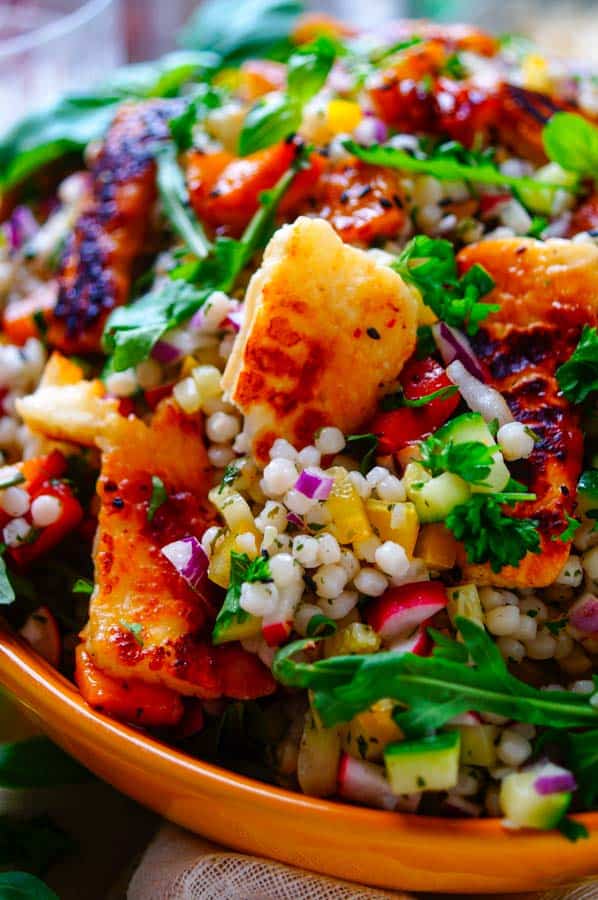 Lekker makkelijk recept voor Couscous Salade met halloumi, een gezonde zomerse salade die kan als doordeweekse avondmaaltijd of als bijgerecht bij BBQ (barbecue). Een vegetarisch receptje klaar in 30min met gegrilde halloumi en stukjes perzik. Ook heerlijk om mee te nemen tijdens een picknick of zet hem gewoon op je weekmenu