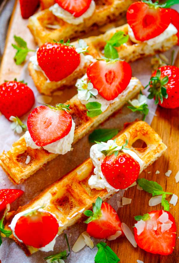 Lekker makkelijk recept voor Brusselse wafels met aardbeien en mascarpone, een heerlijke zomerse klassieker. Krokante wafels afgewerkt met een crème van mascarpone en frisse aardbeien. Super lekker en simpel om te maken