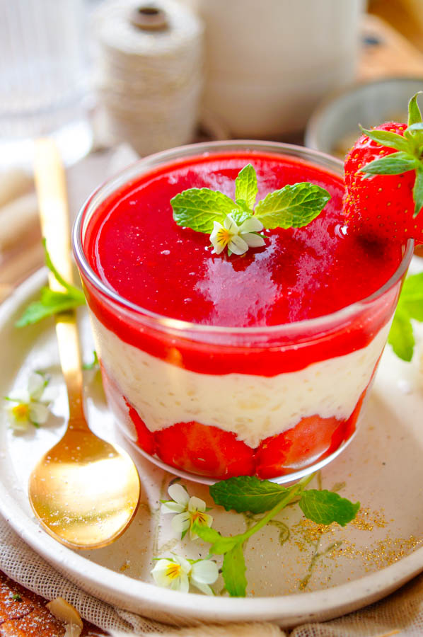 Lekker makkelijk recept voor Rijstpap met aardbeien, een heerlijk simpel zomers dessert dat je makkelijk op voorhand kan maken. Een romige rijst pudding met als geheim ingrediënt witte chocolade. Onderaan in het dessert glaasje vind je verse zomerse aardbeien, daarop de rijstpap afgewerkt met een coulis van aardbeien.