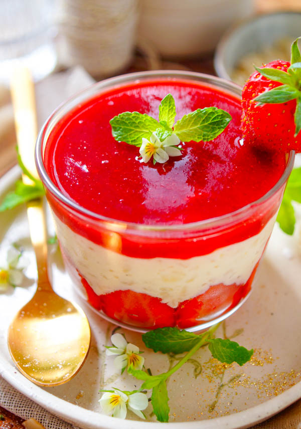 Lekker makkelijk recept voor Rijstpap met aardbeien, een heerlijk simpel zomers dessert dat je makkelijk op voorhand kan maken. Een romige rijst pudding met als geheim ingrediënt witte chocolade. Onderaan in het dessert glaasje vind je verse zomerse aardbeien, daarop de rijstpap afgewerkt met een coulis van aardbeien.