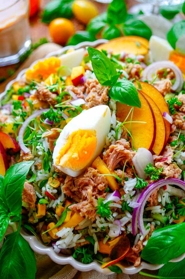 Lekker makkelijk recept voor Rijst salade met tonijn, een gezond doordeweeks gerecht voor op je weekmenu. Een voedzame en eiwitrijke salade met stukjes tonijn, ei, perzik en veel groentjes. Klaar in amper 30min en eenvoudig op voorhand te maken. Ook ideaal als gezonde lunch.