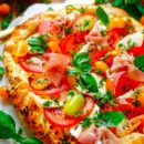 Lekker makkelijk recept voor Caprese plaattaart, een veelzijdig zomers gerecht voor op je weekmenu. Krokant bladerdeeg met pesto crème, tomaat, mozzarella en eventueel wat gedroogde ham. Eenvoudig vegetarisch te maken en klaar in amper 30min. Je kan dit ook als hapje of voorgerecht serveren