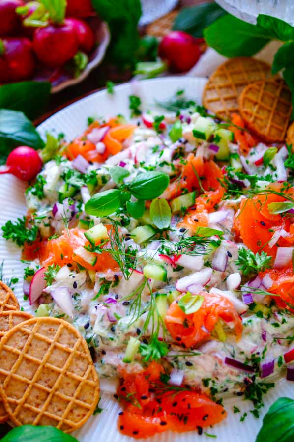 Lekker makkelijk recept voor Zalm Dip, een frisse lichte zomerse dip met gerookte zalm. Een ideaal snel hapje klaar in 20min voor bij de borrel of apero. Een heerlijke combinatie van yoghurt, roomkaas, kruiden, knapperige groentjes en stukjes gerookte zalm. Perfect om in te blijven dippen