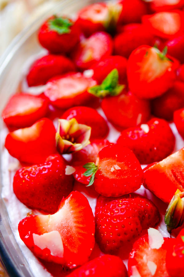 Lekker makkelijk recept voor Trifle met mascarpone en aardbeien, een fris licht zomers dessert klaar in amper 30min. Een grote kom met laagjes vanille cake, een mousse van mascarpone en yoghurt, coulis en aardbeien. Een simpel dessert in een glaasje dat je makkelijk op voorhand kan maken