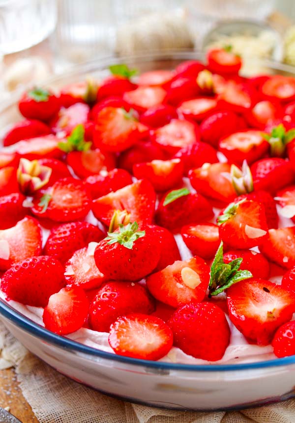 Lekker makkelijk recept voor Trifle met mascarpone en aardbeien, een fris licht zomers dessert klaar in amper 30min. Een grote kom met laagjes vanille cake, een mousse van mascarpone en yoghurt, coulis en aardbeien. Een simpel dessert in een glaasje dat je makkelijk op voorhand kan maken