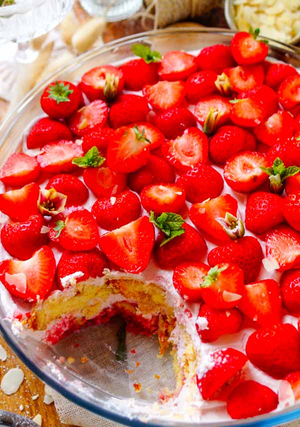 Lekker makkelijk recept voor Trifle met mascarpone en aardbeien, een fris licht zomers dessert klaar in amper 30min. Een grote kom met laagjes vanille cake, een mousse van mascarpone en yoghurt, coulis en aardbeien. Een simpel dessert in een glaasje dat je makkelijk op voorhand kan maken