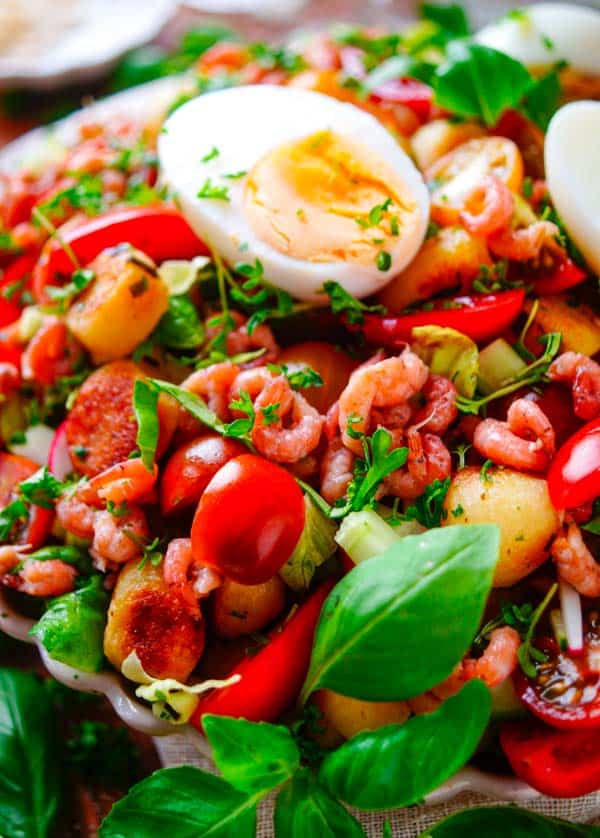 Lekker makkelijk recept voor Aardappelsalade met tomaat en garnalen, simpel zomerse salade klaar in amper 30min. Deze gezonde salade is ideaal voor op je weekmenu want weinig werk en snel klaar. Gebakken aardappeltjes met lekkere kropsla, groentjes, tomaten, grijs garnalen, een eitje en een fris yoghurt sausje.