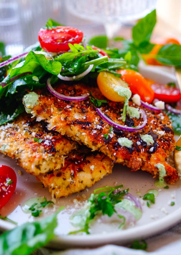 Lekker makkelijk recept voor Italiaanse kip schnitzel, simpel snel gezond gerecht voor op je weekmenu. Heerlijk krokante kip met kruiden en Parmezaanse kaas korst. Daarbij een fris kruidensausje en een snelle salade. Klaar in amper 30min, weinig werk en snel klaar.