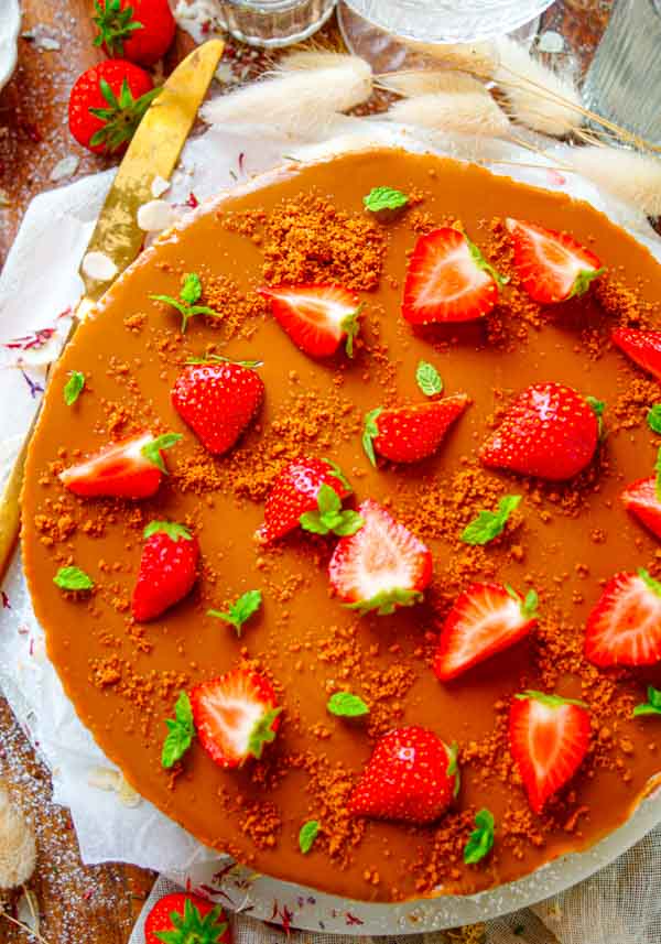 Lekker makkelijk recept voor Yoghurt taart met speculaas en aardbeien, simpel snel gebak waar je geen oven voor nodig hebt. Onderaan een krokant laagje speculaas koekjes. Daarop komt een simpele mousse of bavarois van yoghurt en aardbeien. De taart wordt afgewerkt met speculaaspasta.