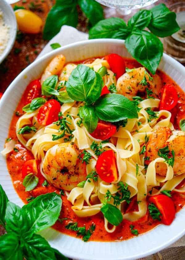 Lekker makkelijk recept voor Tagliatelle met scampi en romige tomatensaus, simpel snel recept voor op je weekmenu. Dit eenvoudige gerecht is klaar in amper 30min en daarom ideaal als doordeweekse avondmaaltijd. We combineren de pasta met heerlijke licht pikante scampi's gecombineerd met een tomatenroomsaus.