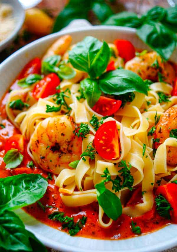 Lekker makkelijk recept voor Tagliatelle met scampi en romige tomatensaus, simpel snel recept voor op je weekmenu. Dit eenvoudige gerecht is klaar in amper 30min en daarom ideaal als doordeweekse avondmaaltijd. We combineren de pasta met heerlijke licht pikante scampi's gecombineerd met een tomatenroomsaus.