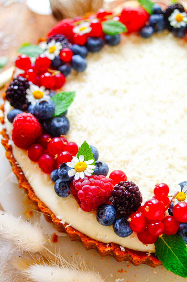 Lekker makkelijk recept voor Speculaas taart met witte chocolade en bosvruchten, simpel en snelle dessert voor bij de koffie of thee. Een krokante speculaas korst met een laagje bosvruchten confituur en een mousse van mascarpone, yoghurt en witte chocolade. Een eenvoudige taart waar je geen oven voor nodig hebt.