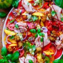 Lekker makkelijk recept voor Tomaten salade met pesto, simpel snelle salade voor bij een BBQ - barbecue of als doordeweekse maaltijd. Fris, licht, zomers en gezond. Dunne plakjes tomaat, perzik, pesto ricotta crème, pesto croutons en mortadella. Heerlijke dagelijkse kost