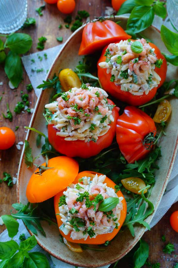 Lekker makkelijk recept voor Tomaat garnaal pastasalade, simpel snel doordeweekse maaltijd voor op weekmenu. Of serveer deze bij een zomers buffet. Tomaten gevuld met een frisse lichte pastasalade met grijze garnalen, ei, perzik groentjes en een lichte cocktailsaus. Heerlijke dagelijkse kost