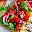 Lekker makkelijk recept voor Pinsa met tomaat, mascarpone en ham, simpel snel zomers gerechtje. Deze kan je serveren als doordeweekse maaltijd of als hapje bij apéro. Met lekker zacht gebakken kerstomaten, kruidige mascarpone en gedroogde ham.