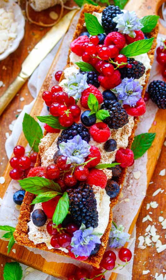 Makkelijk recept voor snelle fruittaart, een simpel dessert waar je geen oven voor nodig hebt. Deze taart heeft een lekkere speculaas bodem met daarin een laagje chocolade, mascarpone room en veel vers fruit.